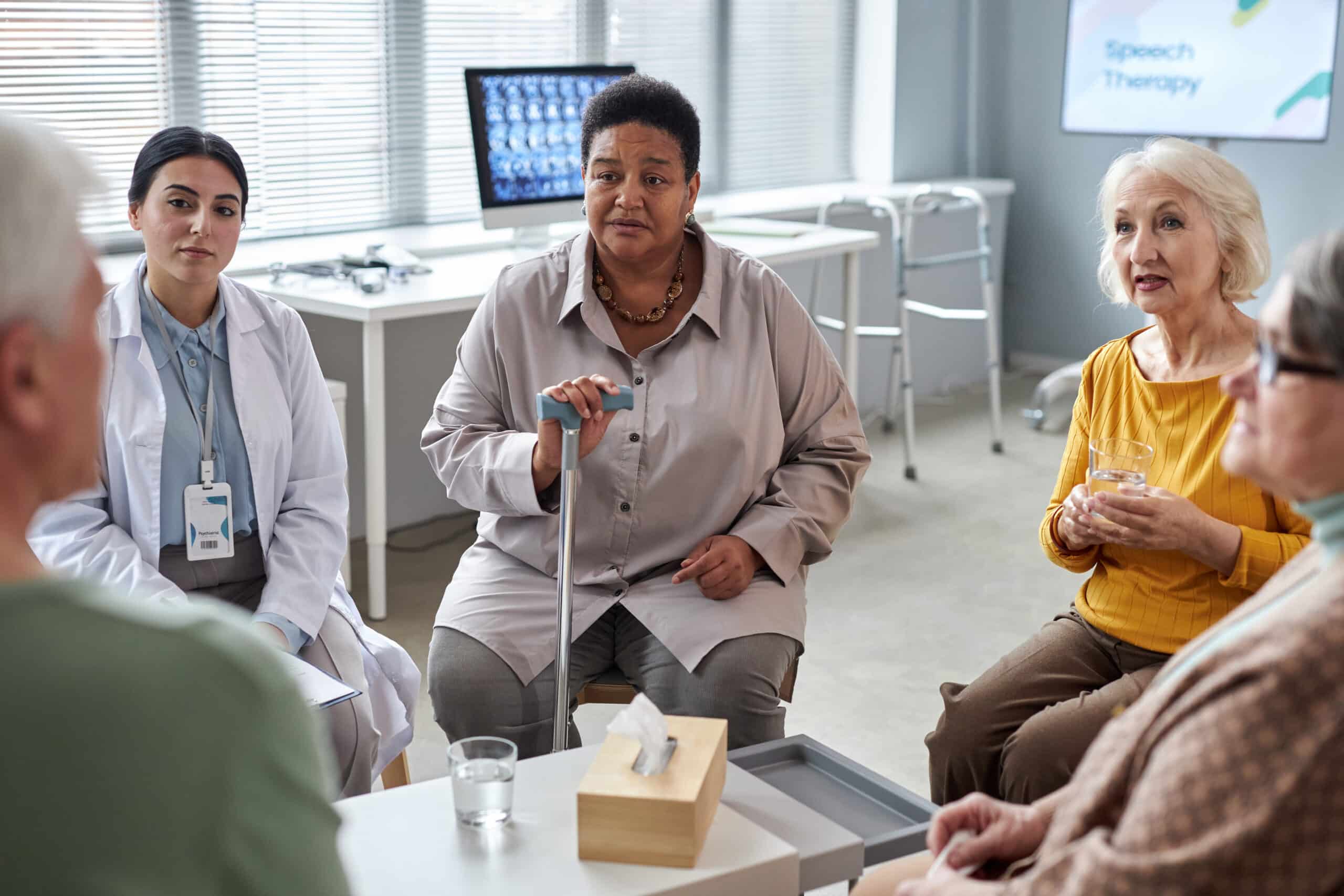 Portrait of senior black woman speaking in mental health support group for elderly people