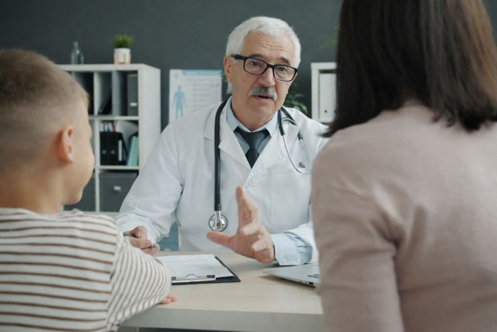 Doctor speaking with a woman and child during a medical consultation in an office.